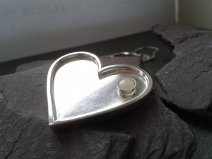 The silver heart pendant set with an opal birthstone