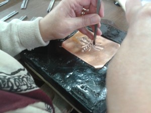 Pushing the design into the reverse of the metal "repousse"