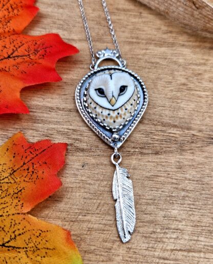 Silver pendant with a porcelain Owl Face and a silver feather